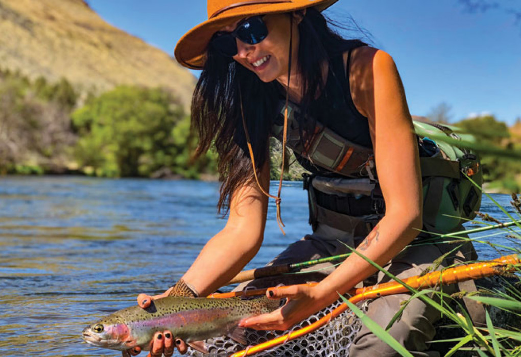 Kayla Lockhart releasing a wild trout